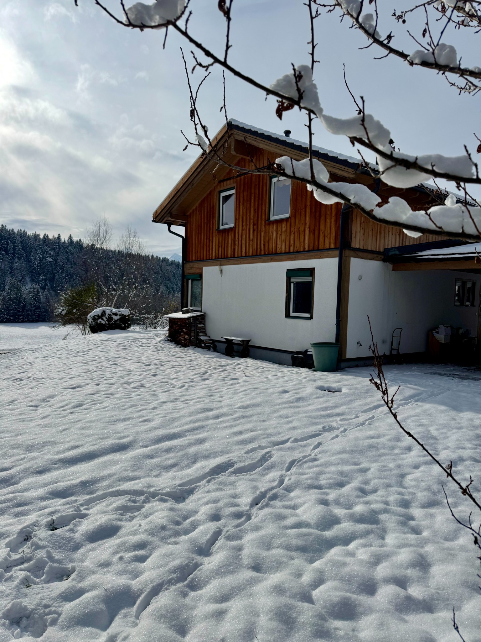 Seitenansicht des Hauses mit verschneiter Wiese