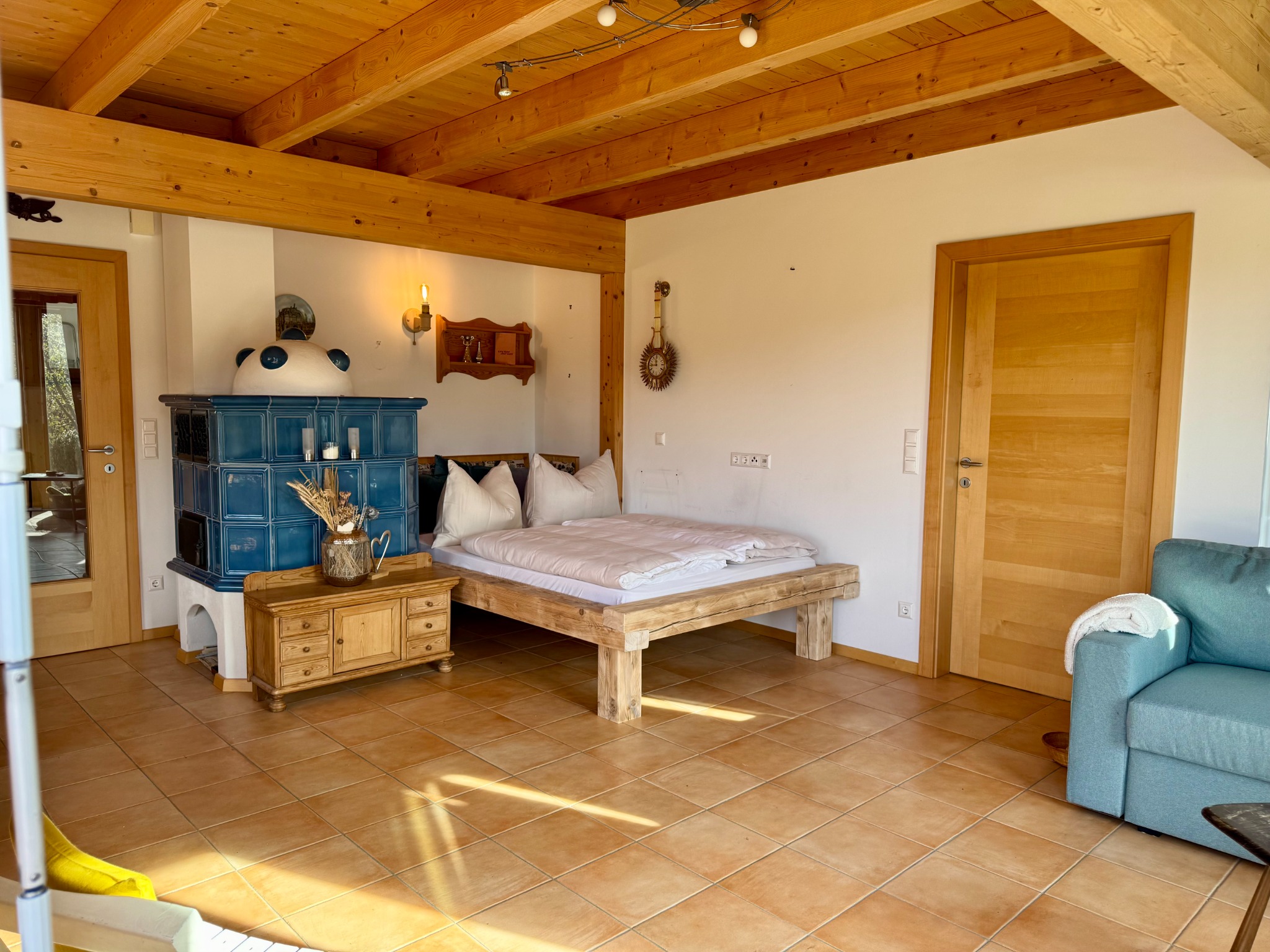 Wohnbereich mit Kachelofen und Bett